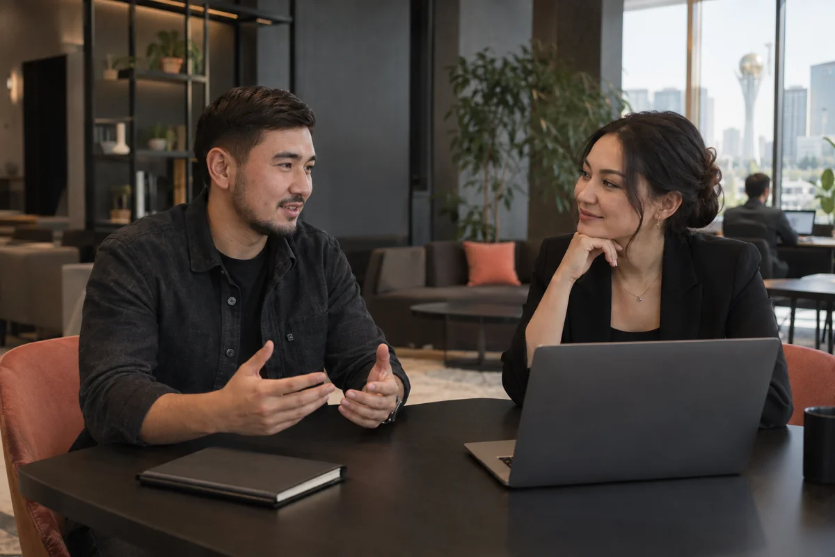 Two professionals discussing a project in a coworking lounge